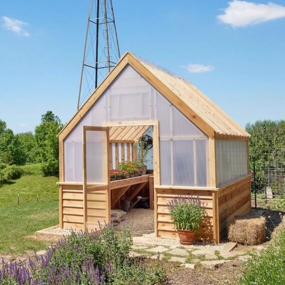 large wooden greenhouse with flowers blooming inside