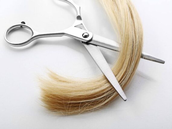 blonde hair being cut by scissors